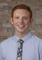 Formal portrait of a smiling Dr Mackay Burgon