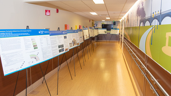 a hallway with a dozen or more research abstract posters on easels 