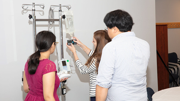 three people standing over an IV bag