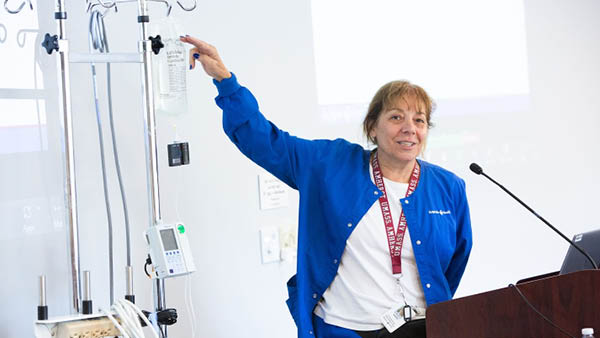 nurse scientist giving a presentation pointing at a IV tube