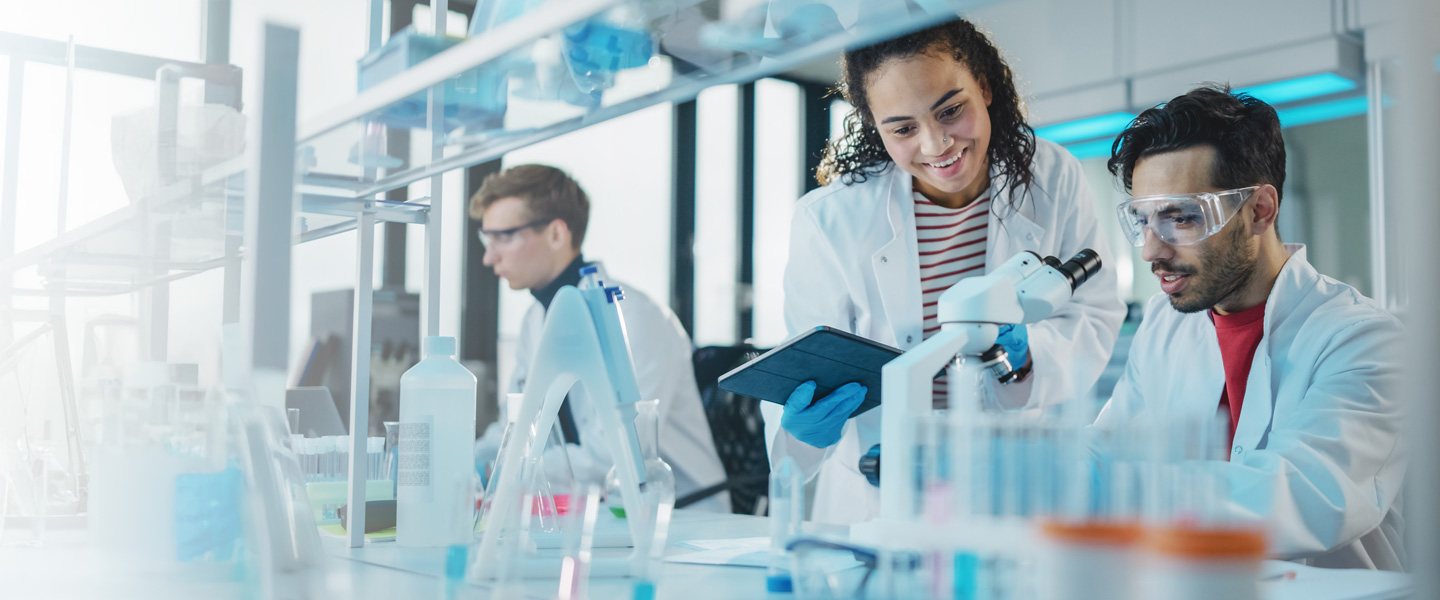 three researchers in a lab with labcoats