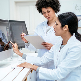 two researchers looking over data on a computer screen
