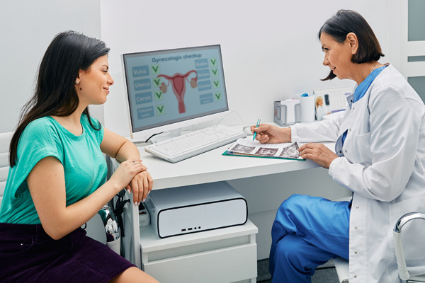 an ob/gyn doctor showing a patient a diagram of ovarian cancer
