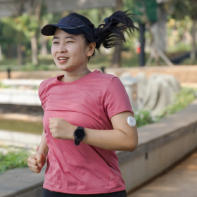 woman with diabetes running through a park for exercise