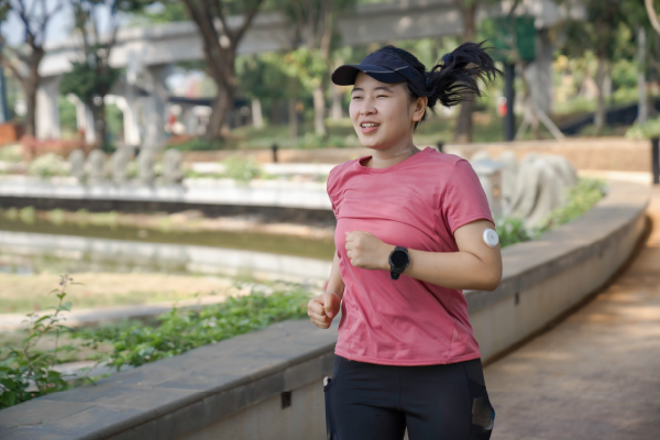 woman with diabetes running through a park for exercise