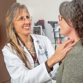 convenient care doctor grimes checking patient’s neck area using her fingers