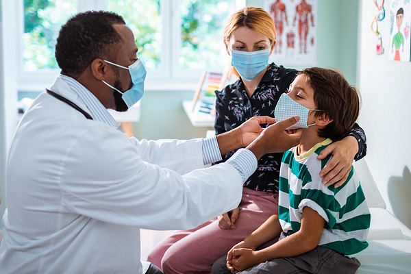 A doctor checks the throat glands of a pediatric patient