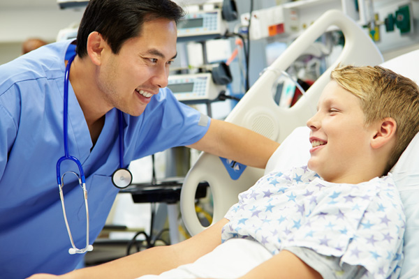 a doctor talking to a child in a hospital bed