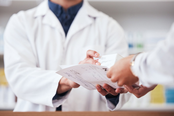 a pharmacist handing over a prescription to a patient