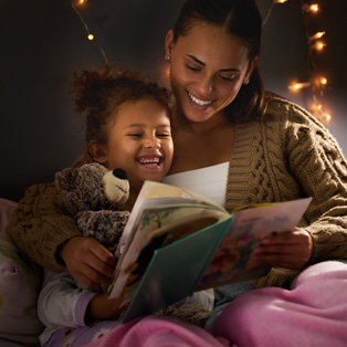 a young mother reading her daughter a bedtime story