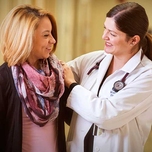 a doctor with their hands on the shoulders of a patient