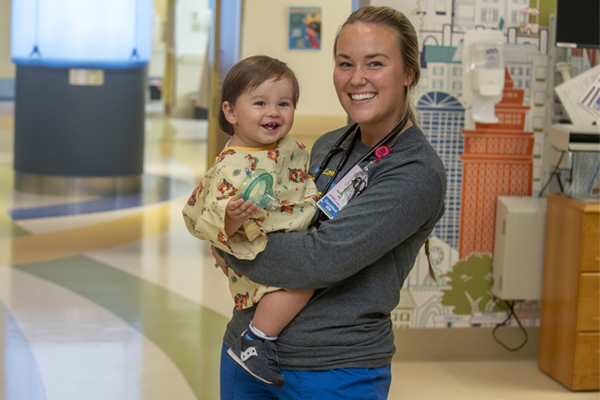 pediatric patient being held by a Baystate Health employee