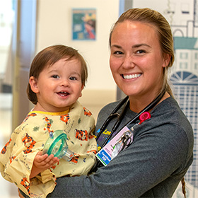 pediatric patient being held by a Baystate Health employee